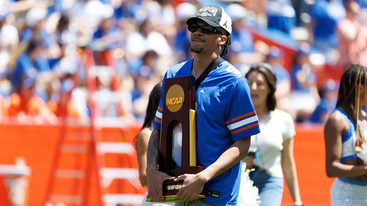 Florida Gators guard Will Richard (5) holds a trophy while walking onto the field during the National Championship celebration at Ben Hill Griffin Stadium.