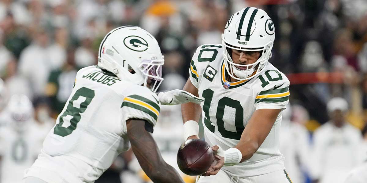 Green Bay Packers quarterback Jordan Love (10) hands off the ball to running back Josh Jacobs (8) in the first quarter against the Washington Commanders at Lambeau Field