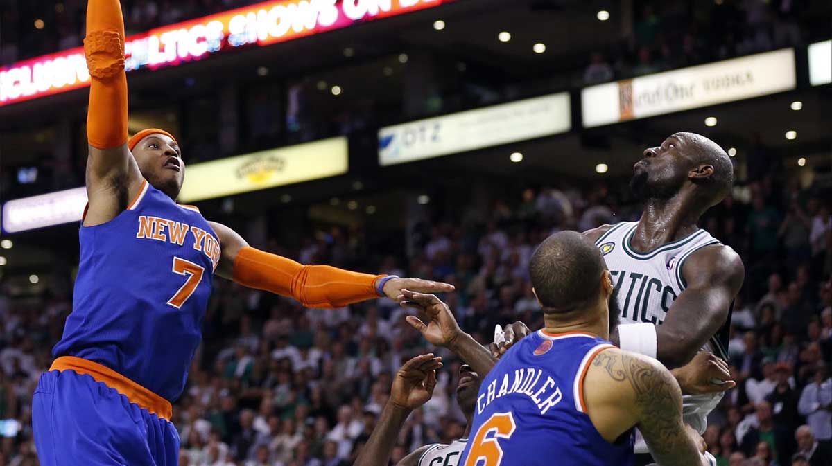 Knicks small forward Carmelo Anthony (7) shoots against Boston Celtics center Kevin Garnett (5) in game six of the first round of the 2013 NBA Playoffs at TD Garden. The New York Knicks defeated the Celtics 88-80 with his all-time starting five, Allen Iverson, and Derrick Rose in the background