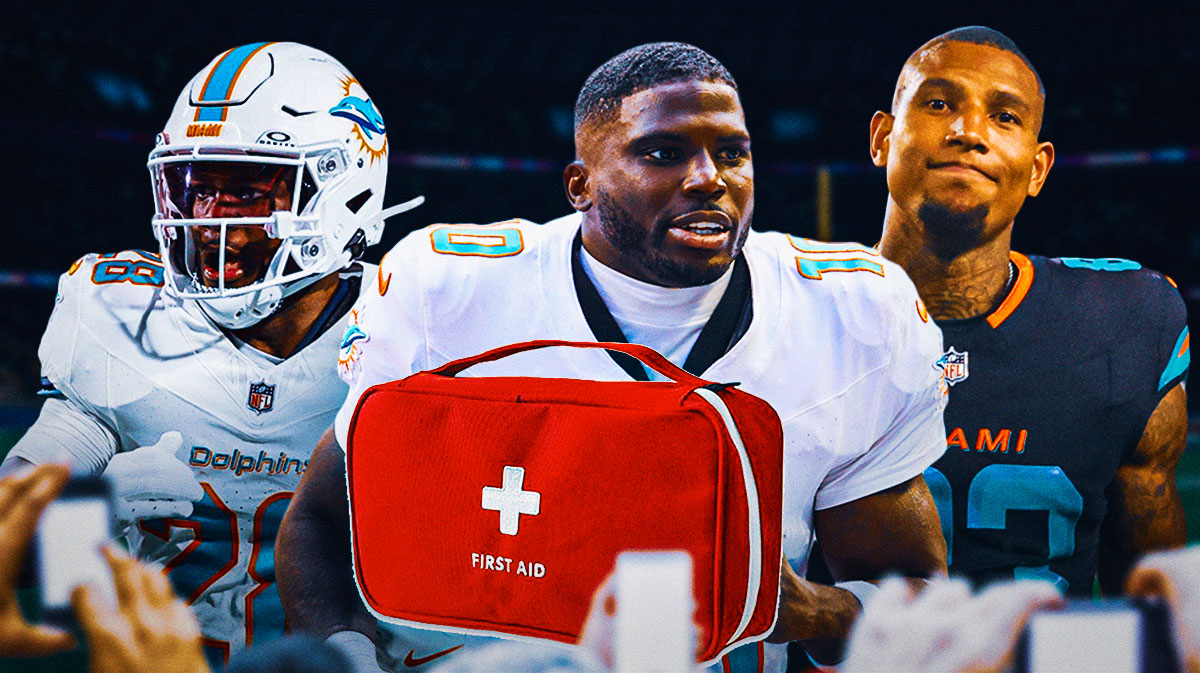 Fantasy football Dolphins WR Tyreek Hill on the injury cart (center). Dolphins RB De'Von Achane and Dolphins TE Darren Waller behind him.