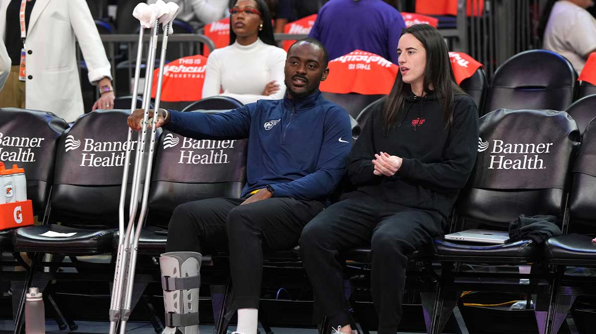 Indiana Fever guard Caitlin Clark (22) talks to coach Keith Porter before a game against the Phoenix Mercury at PHX Arena.