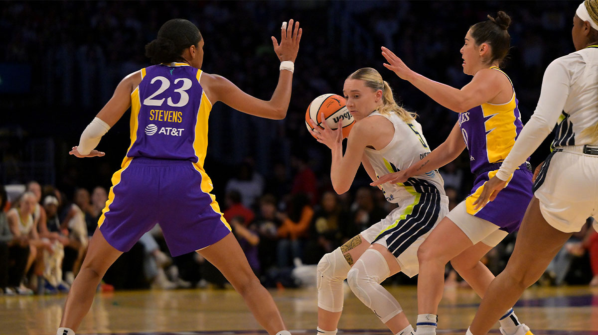 Dallas Wings guard Paige Bueckers (5) is defended by Los Angeles Sparks forward Azura Stevens (23) and guard Kelsey Plum (10) during the first half at Crypto.com Arena.