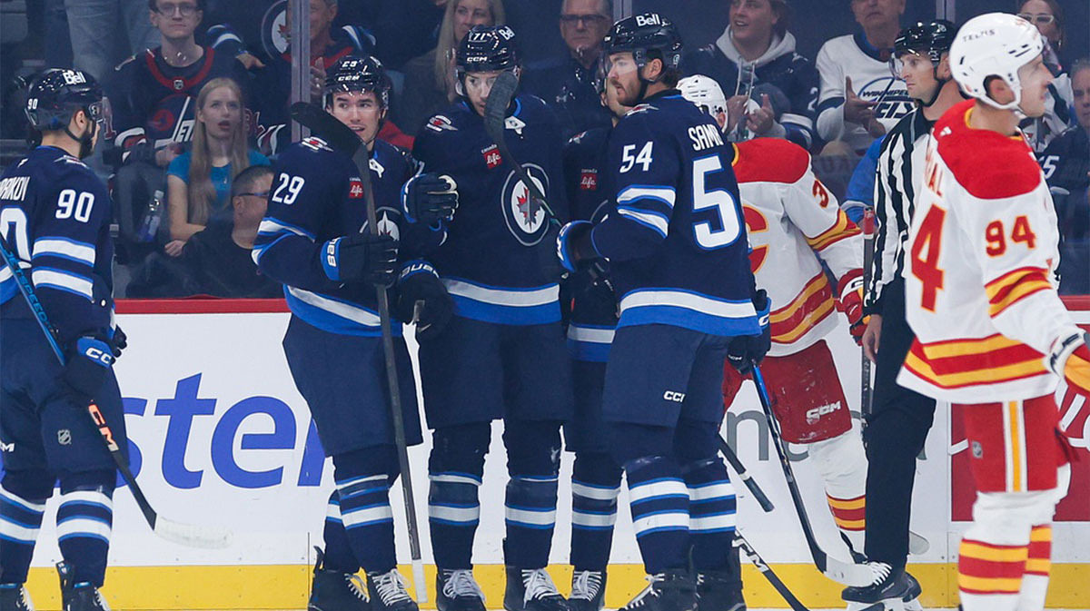 Winnipeg Jets forward Walker Duehr (71) is congratulated by his teammates on his goal against the Calgary Flames.