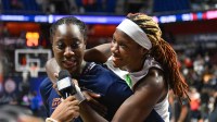 ; Atlanta Dream guard Rhyne Howard (10) interacts with Connecticut Sun center Tina Charles (31) as she is interviewed after a game at Mohegan Sun Arena.