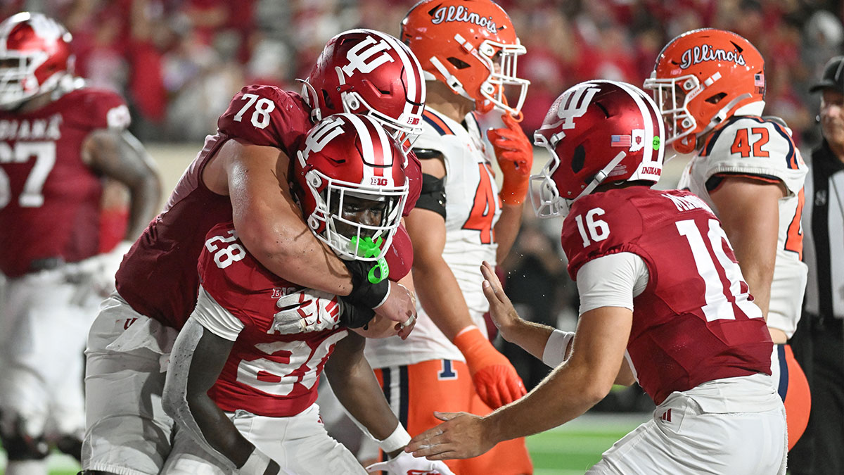Indiana Hoosiers offensive lineman Pat Coogan (78) and Indiana Hoosiers quarterback Fernando Mendoza (15) celebrate with Indiana Hoosiers running back Khobie Martin (28) after a touchdown during the second half against the Illinois Fighting Illini at Memorial Stadium.