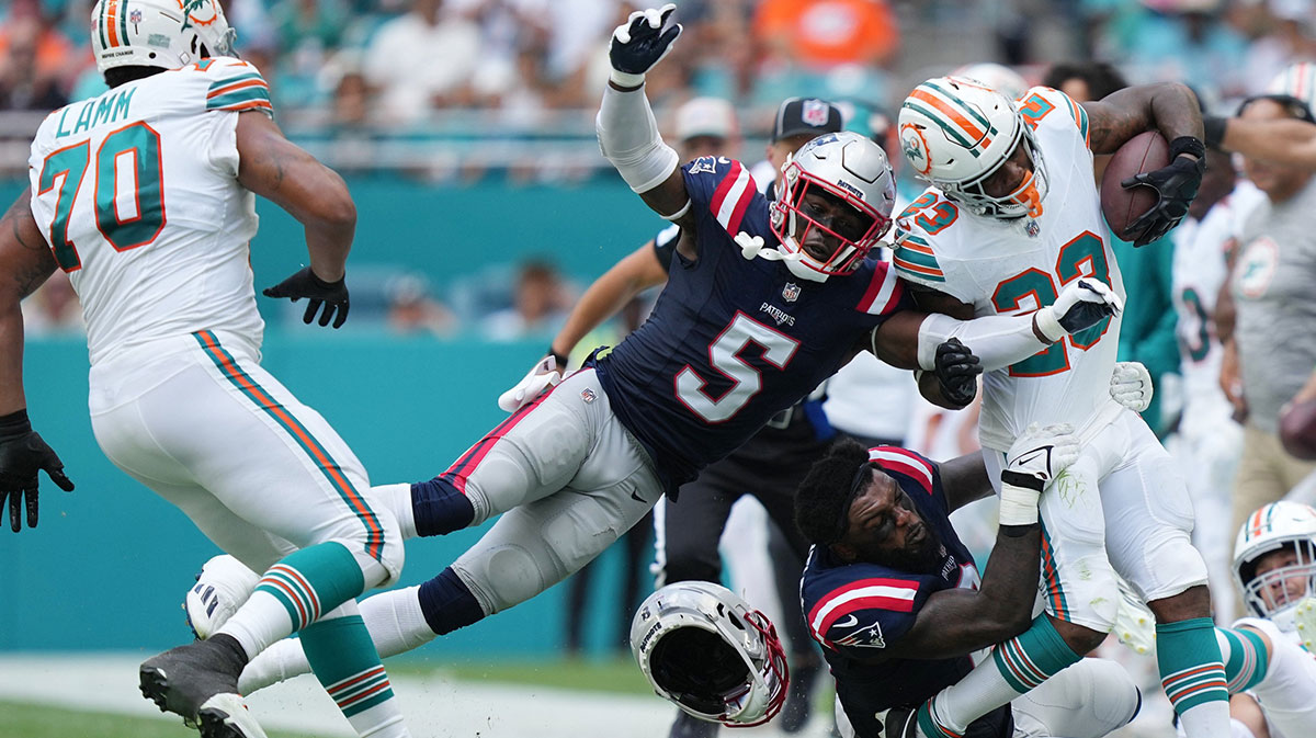 New England Patriots linebacker Ja'Whaun Bentley (8) drags down Miami Dolphins running back Jeff Wilson Jr. (23) as safety Jabrill Peppers (5) follows on the play during the first half of an NFL game at Hard Rock Stadium in Miami Gardens, Oct. 29, 2023.