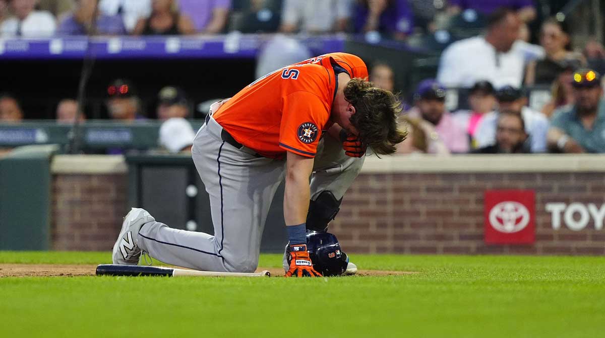 Houston Astros center fielder Jake Meyers (6) kneels on the field after getting hit by a pitch in the sixth inning against the Colorado Rockies at Coors Field.