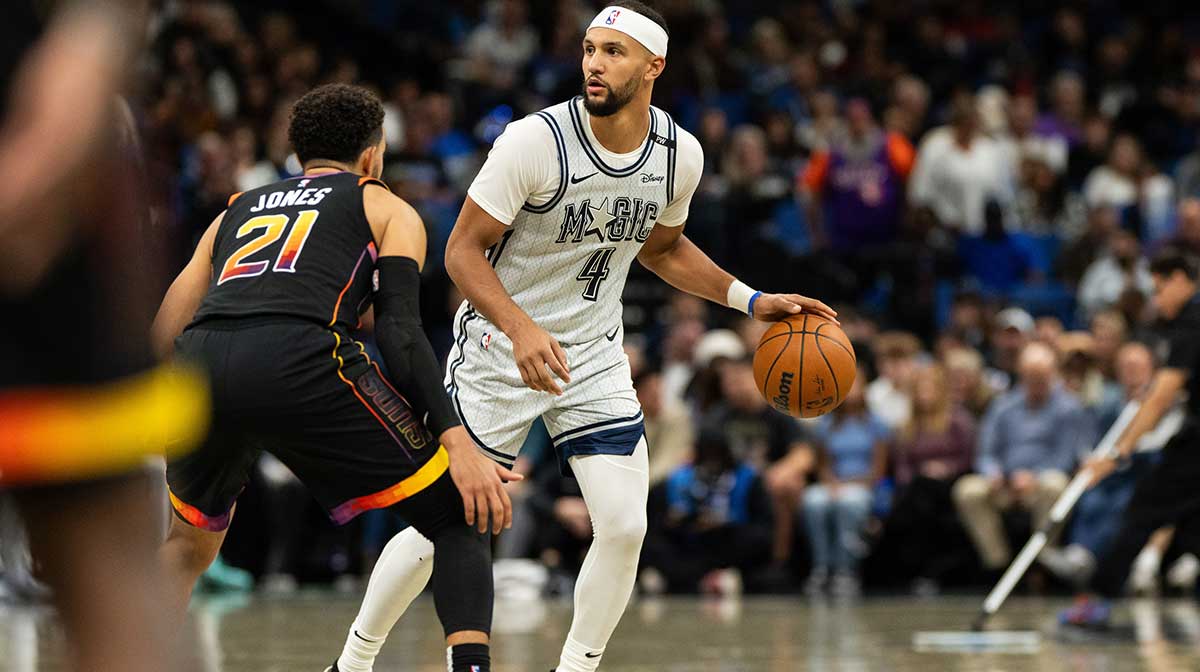 Orlando Magic guard Jalen Suggs (4) dribbles the ball against Phoenix Suns guard Tyus Jones (21) in the second quarter at Kia Center.