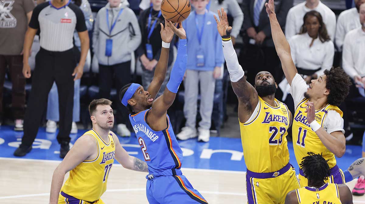 Oklahoma City Thunder guard Shai Gilgeous-Alexander (2) shoots as Los Angeles Lakers forward LeBron James (23) and center Jaxson Hayes (11) defend the shot during the first quarter at Paycom Center