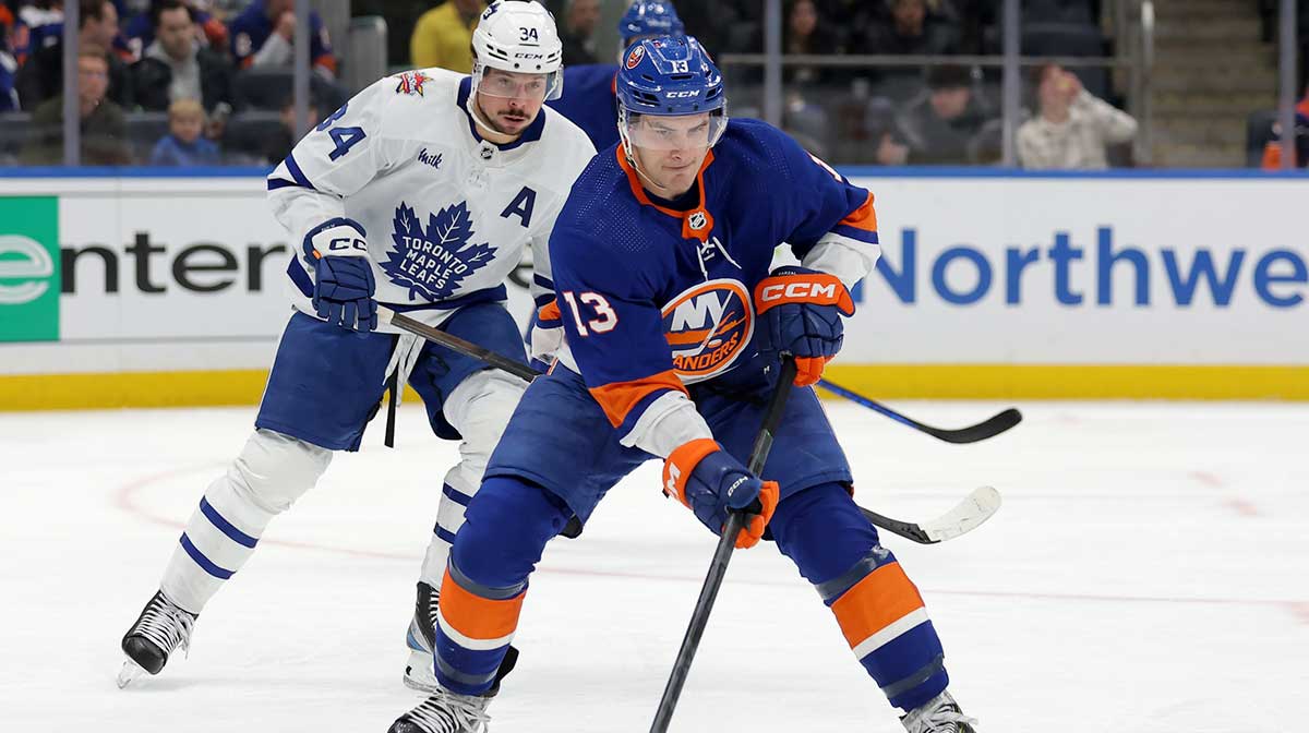 New York Islanders center Mathew Barzal (13) skates with the puck against Toronto Maple Leafs center Auston Matthews (34) during the third period at UBS Arena. Mandatory Credit: Brad Penner-Imagn Images