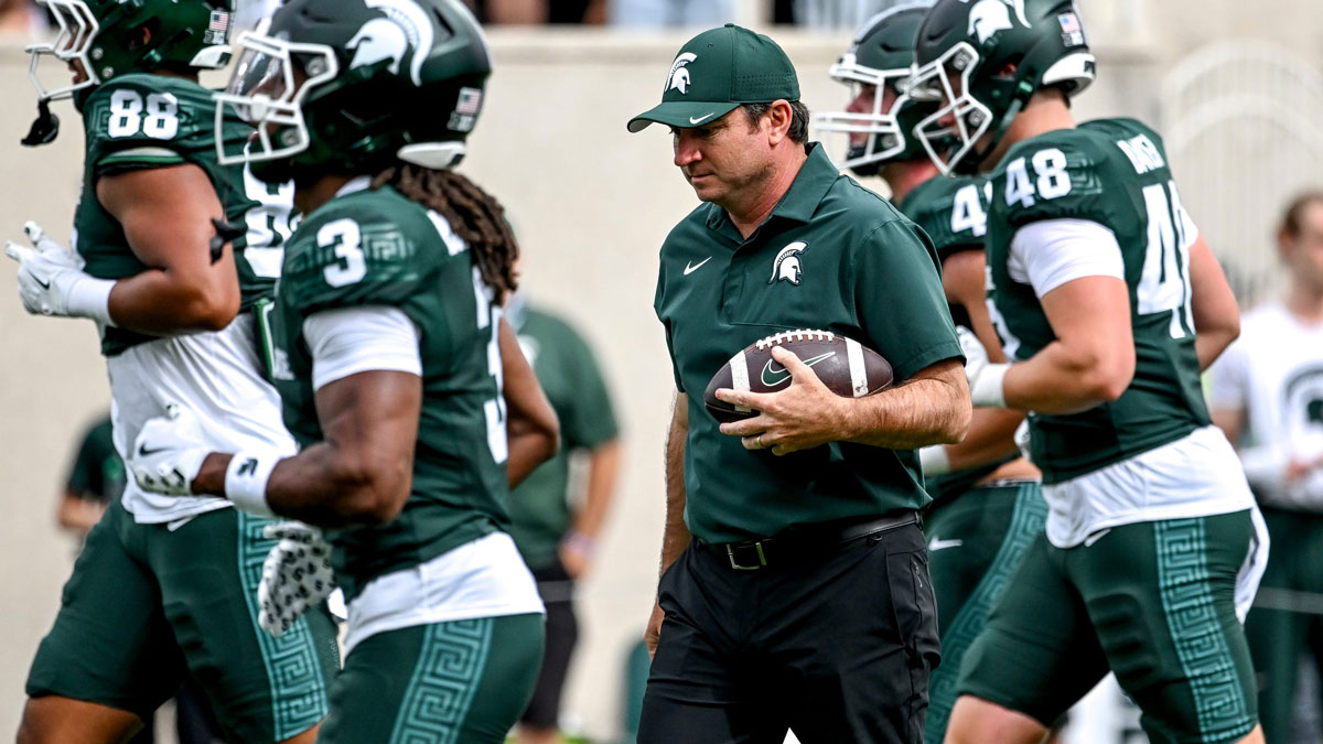 Michigan State's head coach Jonathan Smith holds a football as the team warms up before the game against Youngstown State on Saturday, Sept. 13, 2025, at Spartan Stadium in East Lansing.
