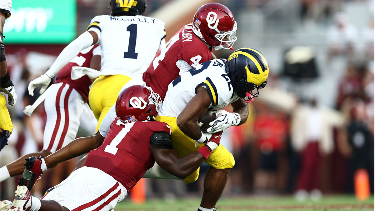 Michigan Wolverines running back Justice Haynes (22) carries the ball as Oklahoma Sooners linebacker Sammy Omosigho (7) ttempts to make the tackle during the first half at Gaylord Family-Oklahoma Memorial Stadium.