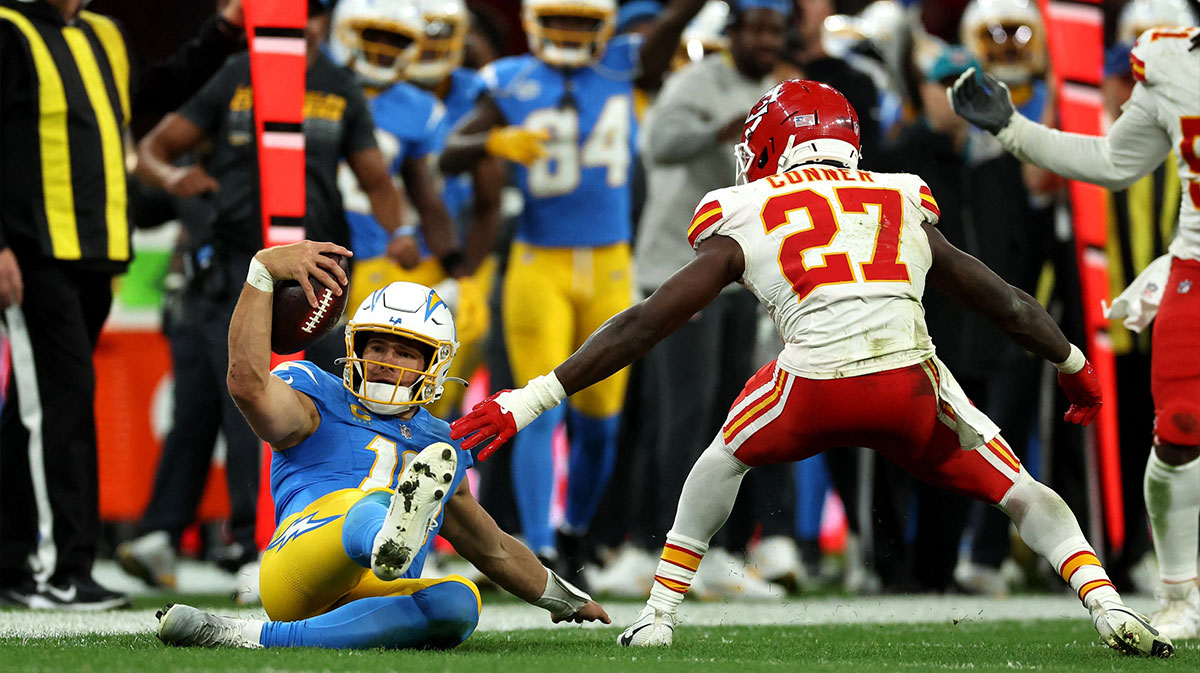 Los Angeles Chargers quarterback Justin Herbert (10) picks up a first down against Kansas City Chiefs safety Chamarri Conner (27) during a NFL game at Corinthians Arena.