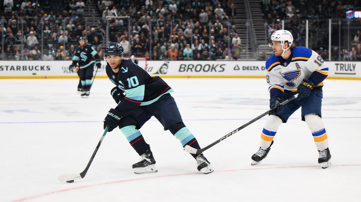 Seattle Kraken center Matty Beniers (10) plays the puck while defended by St. Louis Blues center Robert Thomas (18) during overtime at Climate Pledge Arena.
