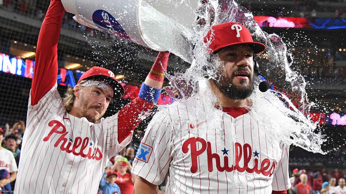 Philadelphia Phillies outfielder Kyle Schwarber (12) has water dumped on him by second base Bryson Stott (5) after win against the New York Mets at Citizens Bank Park.