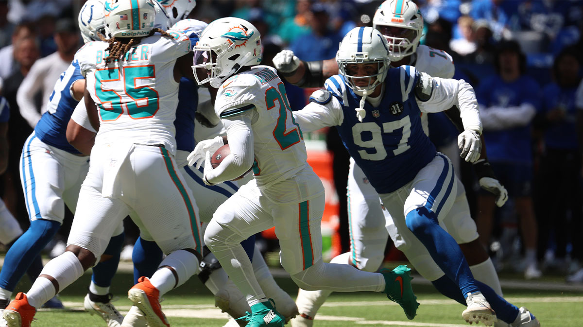 Miami Dolphins running back De'Von Achane (28) runs against Indianapolis Colts defensive end Laiatu Latu (97) during the first half at Lucas Oil Stadium.