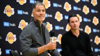 Lakers general manager Rob Pelinka, left, speaks during a press conference to preview the 2025-26 season at UCLA Health Training Center