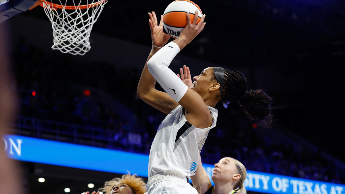 Jul 16, 2025; Arlington, Texas, USA;Las Vegas Aces center A'ja Wilson (22) scores a layup past Dallas Wings guard Paige Bueckers (5) during the first half at College Park Center. Mandatory Credit: Chris Jones-Imagn Images