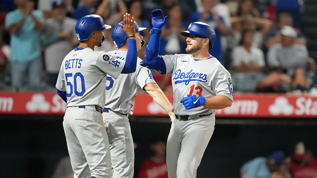 Los Angeles Dodgers third baseman Max Muncy (13) celebrates with shortstop Mookie Betts (50) after hitting a three-run home run in the eighth inning against the Los Angeles Angels at Angel Stadium.