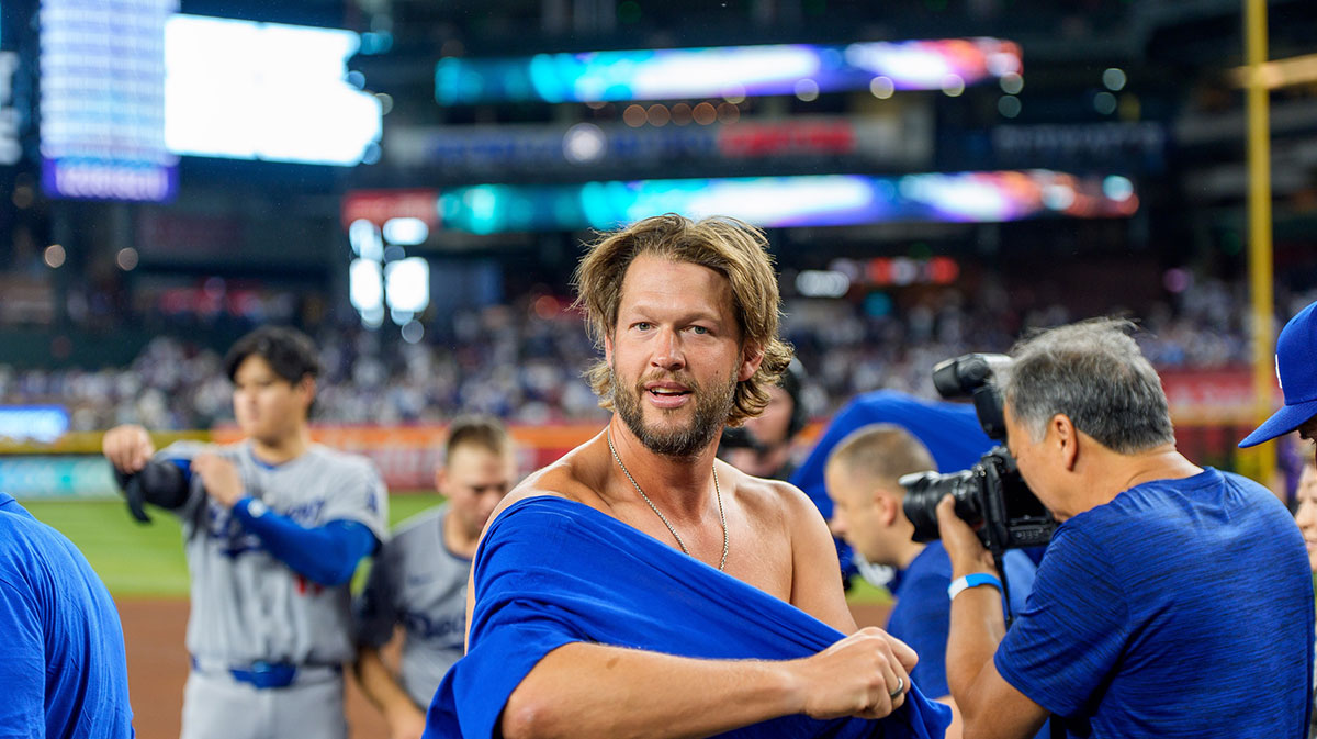 Los Angeles Dodgers pitcher Clayton Kershaw (22) reacts as he puts on his National League West championship shirt after beating the Arizona Diamondbacks at Chase Field.