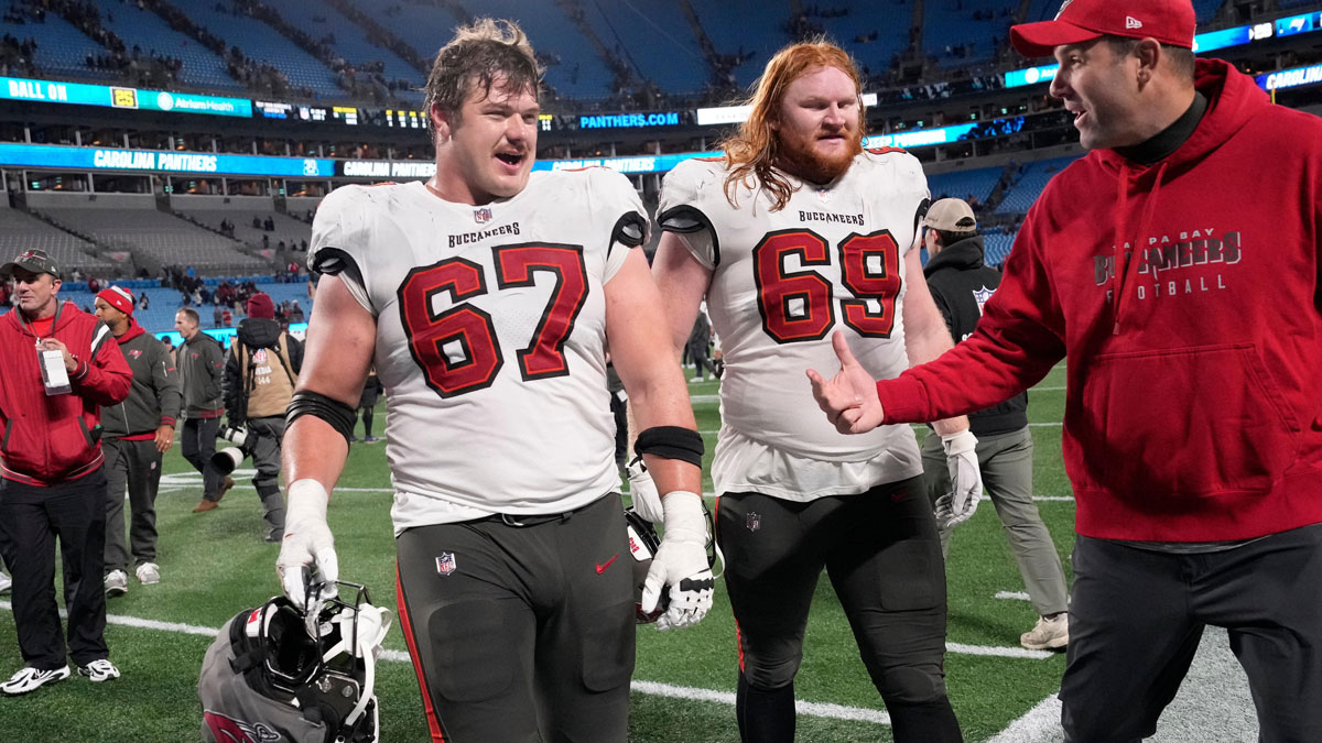 Tampa Bay Buccaneers offensive tackle Luke Goedeke (67) and guard Cody Mauch (69) leave the field after the game at Bank of America Stadium.
