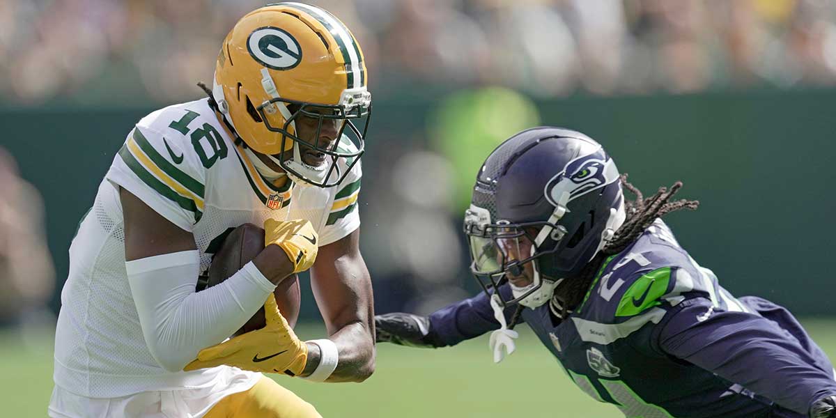 Green Bay Packers wide receiver Malik Heath (18) makes a catch before being tackles by Seattle Seahawks cornerback Shaquill Griffin (24) during the first quarter of their preseason game Saturday, August 23, 2025 at Lambeau Field in Green Bay, Wisconsin.
