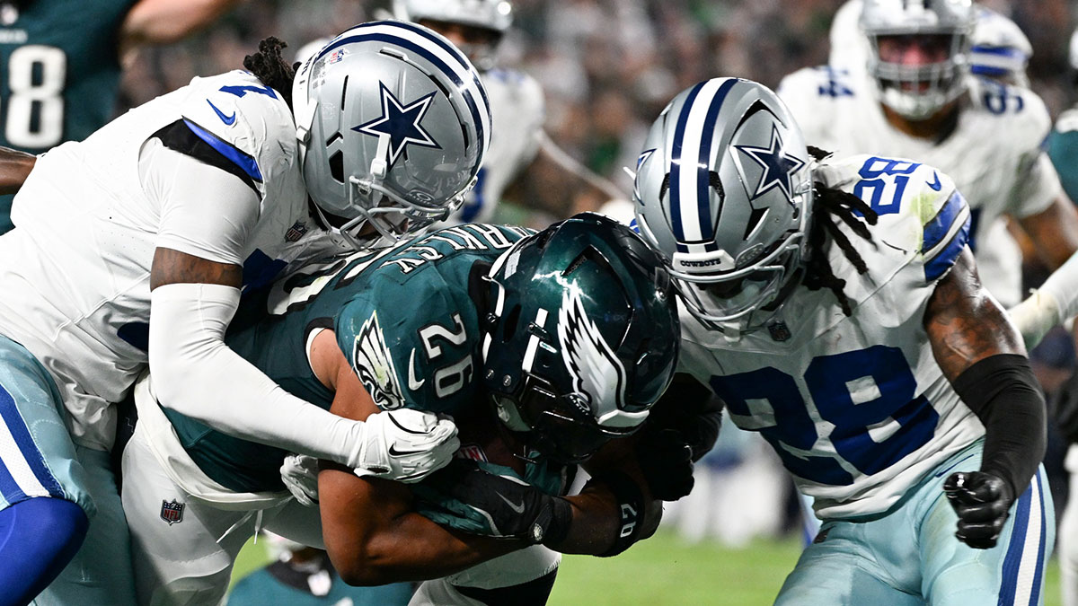 Philadelphia Eagles running back Saquon Barkley (26) carries the ball for a touchdown defended by Dallas Cowboys cornerback Trevon Diggs (7) and safety Malik Hooker (28) during the second quarter of the game at Lincoln Financial Field.