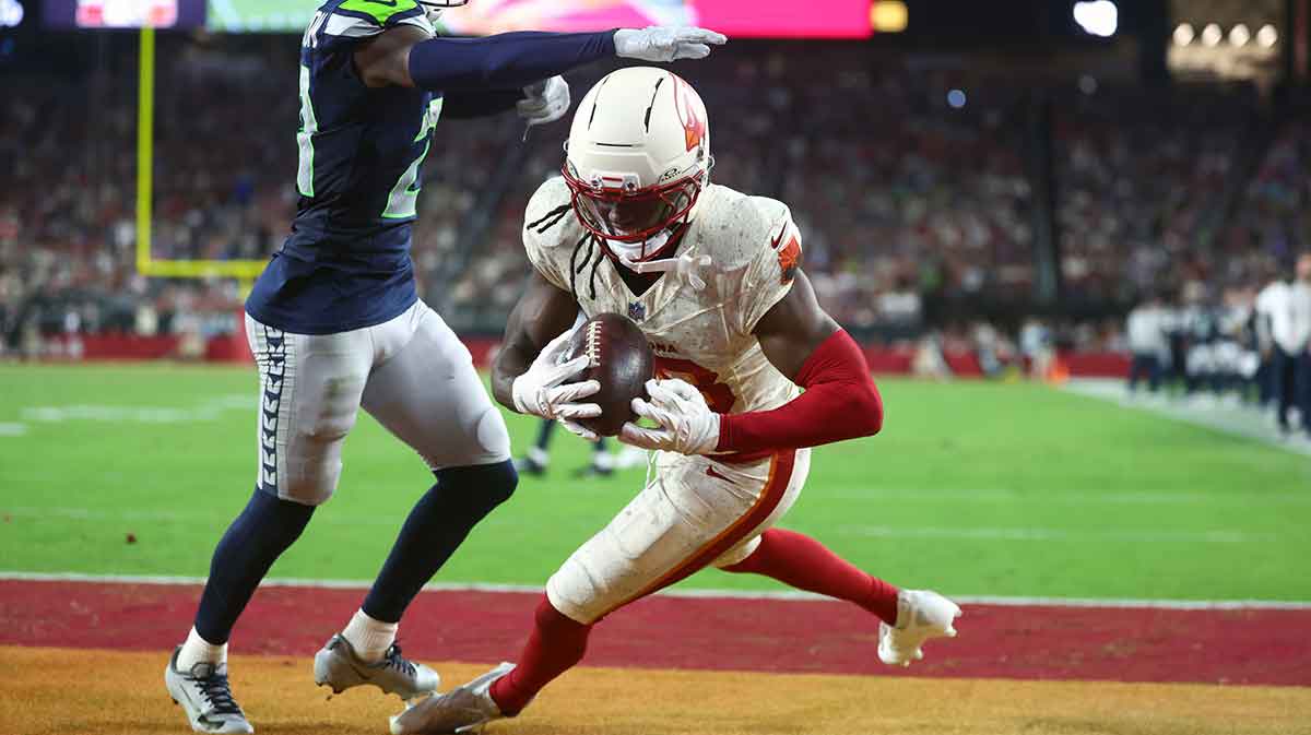 Arizona Cardinals wide receiver Marvin Harrison Jr. (18) makes a catch for a touchdown against Seattle Seahawks cornerback Devon Witherspoon (21) in the fourth quarter at State Farm Stadium.