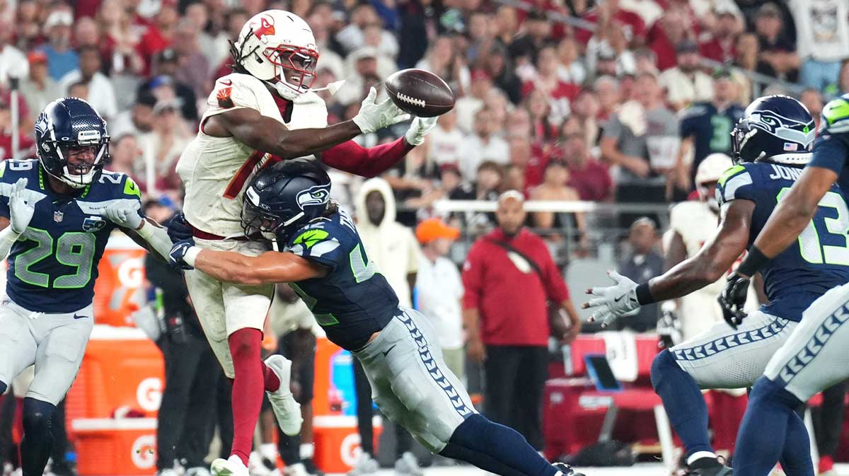 Arizona Cardinals wide receiver Marvin Harrison Jr. (18) cannot make a catch against Seattle Seahawks linebacker Drake Thomas (42) as linebacker Ernest Jones IV (13) intercepts the ball in the second quarter at State Farm Stadium. 