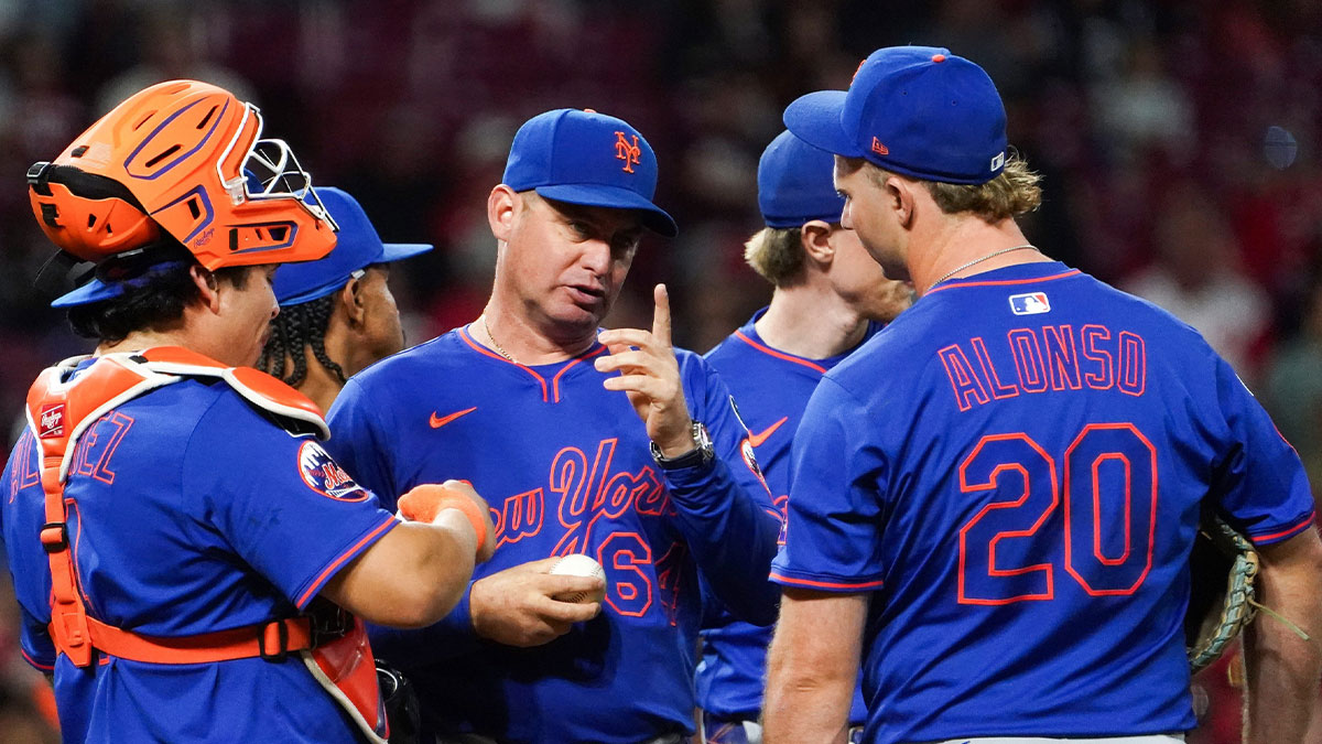 New York Mets manager Carlos Mendoza (64) speaks with players at the pitchers mound in the seventh inning of a MLB game between the Cincinnati Reds and New York Mets, Saturday, Sept. 6, 2025, at Great American Ball Park in downtown Cincinnati. Reds won 6-3.