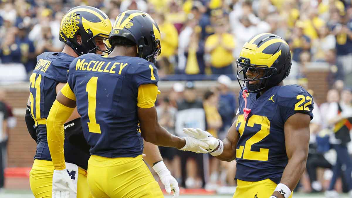 Michigan Wolverines running back Justice Haynes (22) receives congratulations from offensive lineman Greg Crippen (51) and wide receiver Donaven McCulley (1) after scoring in the first half against the Central Michigan Chippewas at Michigan Stadium.