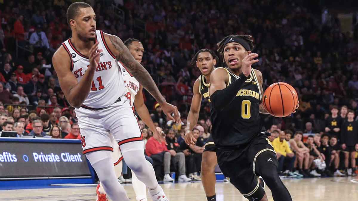 Michigan Wolverines guard Dug McDaniel (0) drives past St. John's Red Storm center Joel Soriano (11) in the first half at Madison Square Garden.