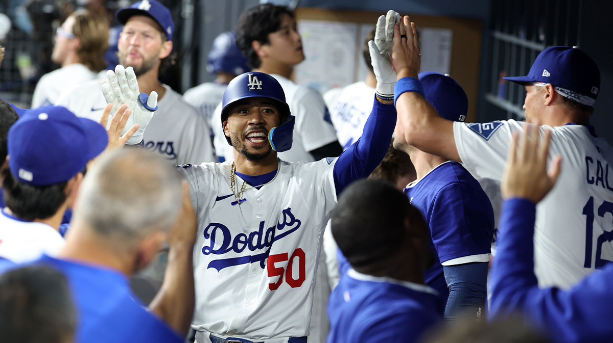 Los Angeles Dodgers shortstop Mookie Betts (left) is greeted in the dugout after hitting a solo home run during the fifth inning against the San Francisco Giants at Dodger Stadium.