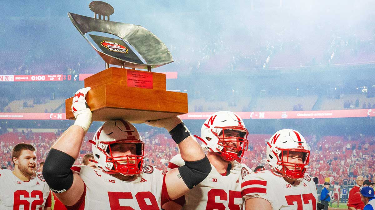 Nebraska Cornhuskers offensive lineman Henry Lutovsky (59) hoists the Battle Sports Kansas City Classic trophy as he walks off the field after defeating the Cincinnati Bearcats at GEHA Field at Arrowhead Stadium.