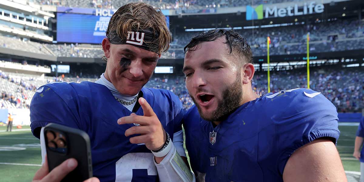 New York Giants quarterback Jaxson Dart (6) and running back Cam Skattebo (44) record a video on a smartphone after defeating the Los Angeles Chargers at MetLife Stadium.