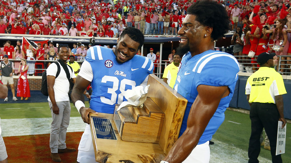 Mississippi Rebels linebacker Tyler Banks (38) and wide receiver De'Zhaun Stribling (1) carry the Magnolia Bowl trophy around the field after defeating the LSU Tigers at Vaught-Hemingway Stadium.