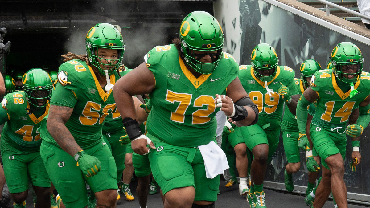 Oregon’s Iapani Laloulu, center, leads the team onto the field before the game against Oklahoma State at Autzen.