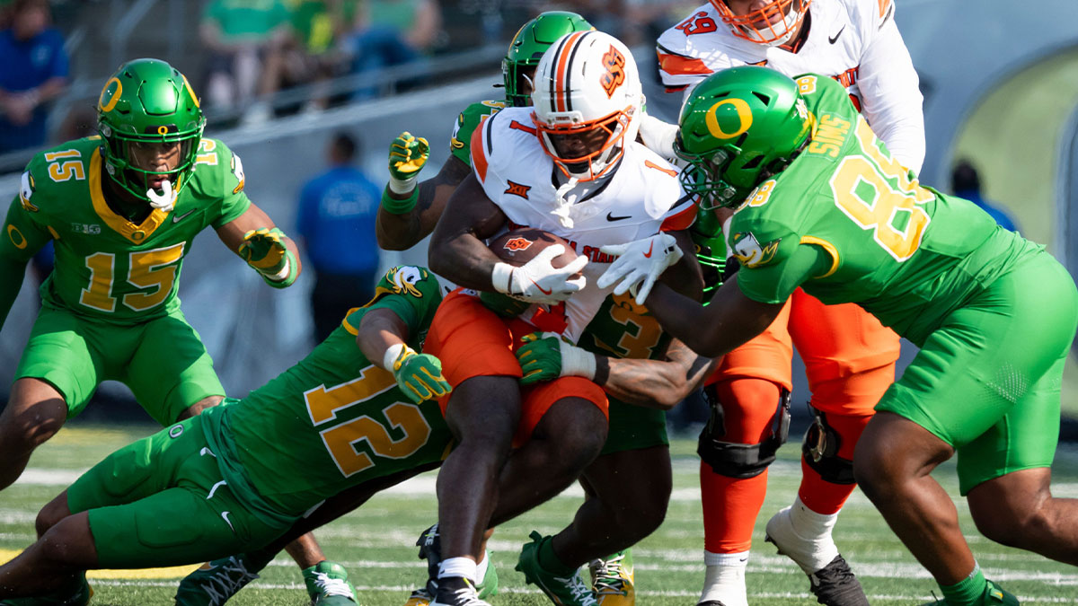 Oklahoma State running back Kalib Hicks is brought down by a pack of Oregon defenders as the Oregon Ducks host the Oklahoma State Cowboys on Sept. 6, 2025, at Autzen Stadium in Eugene, Oregon.