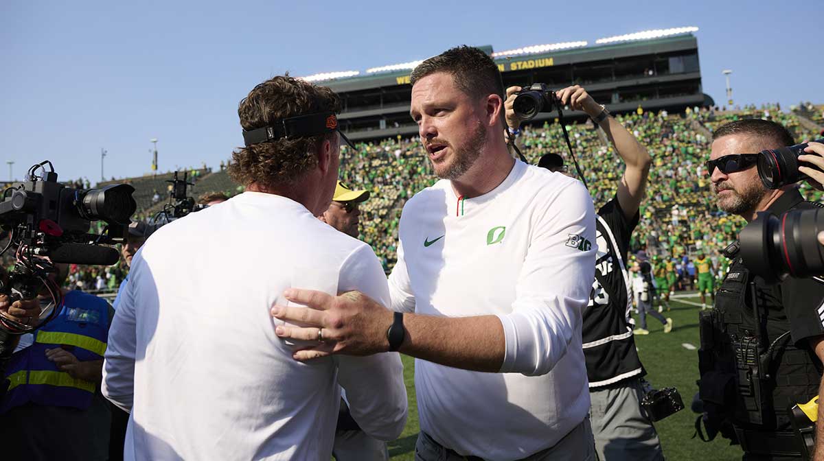Oregon Ducks head coach Dan Lanning shakes the hand of Oklahoma State Cowboys head coach Mike Gundy after a game at Autzen Stadium.