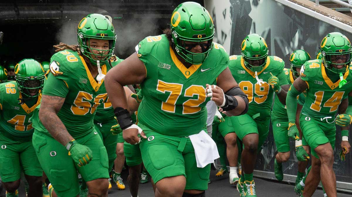 Oregon’s Iapani Laloulu, center, leads the team onto the field before the game against Oklahoma State at Autzen.