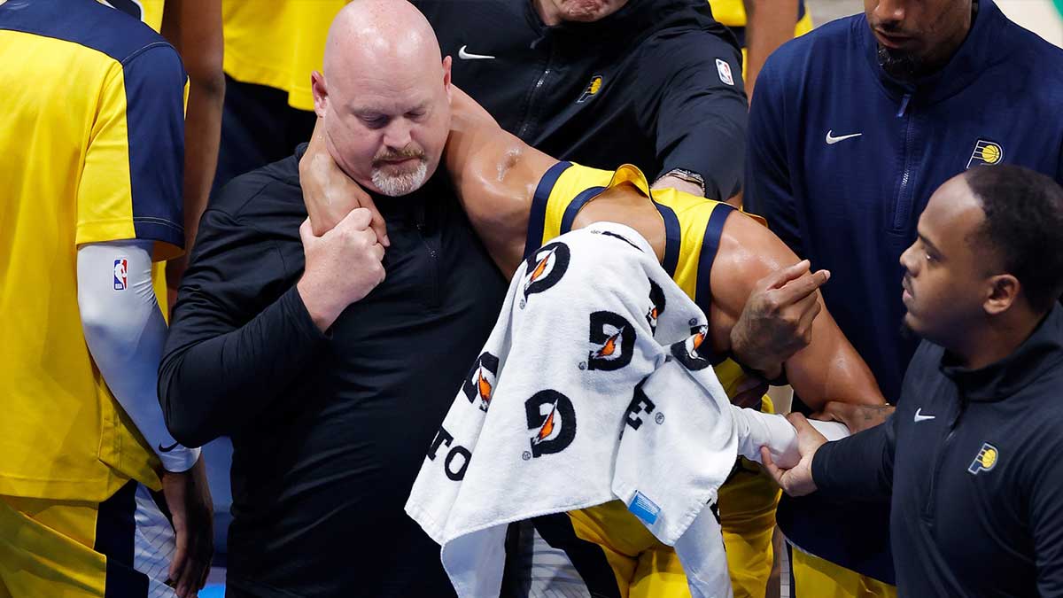 Pacers guard Tyrese Haliburton (0) is assisted after an apparent injury following a play against the Oklahoma City Thunder during the first half of game seven of the 2025 NBA Finals at Paycom Center