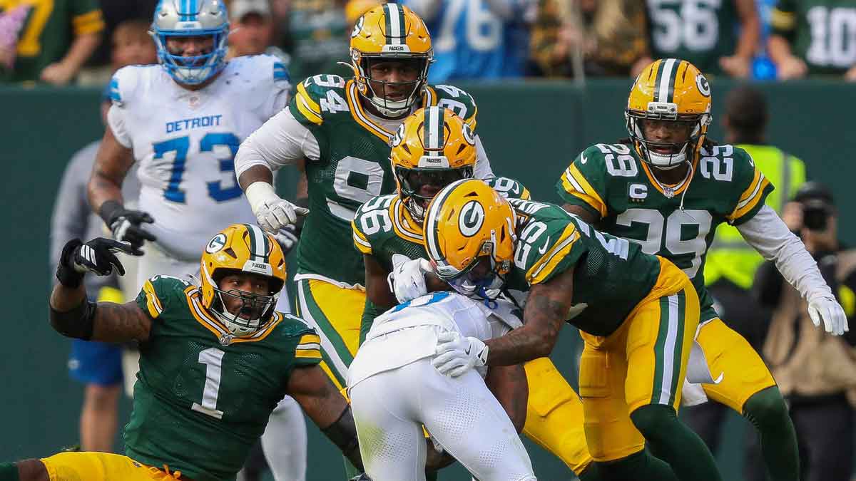 Green Bay Packers defensive end Micah Parsons (1), linebacker Edgerrin Cooper (56) and cornerback Keisean Nixon (25) team up to stop Detroit Lions running back Jahmyr Gibbs (0) on Sunday