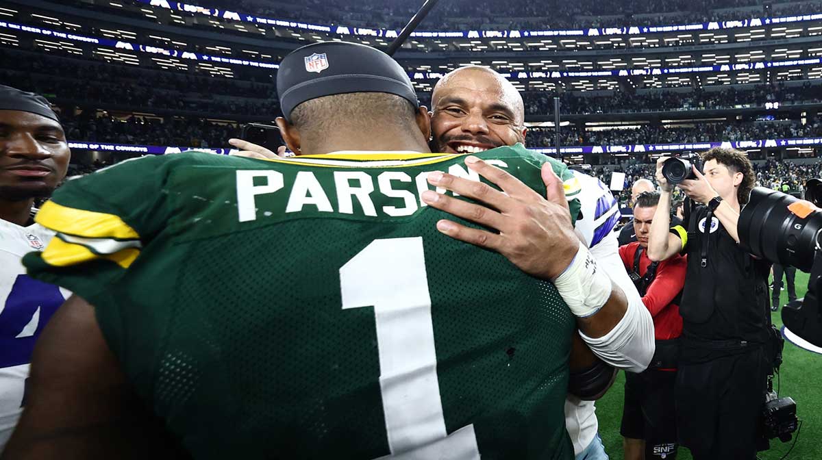 Green Bay Packers defensive end Micah Parsons (1) and Dallas Cowboys quarterback Dak Prescott (4) embrace after the tie game at AT&T Stadium.