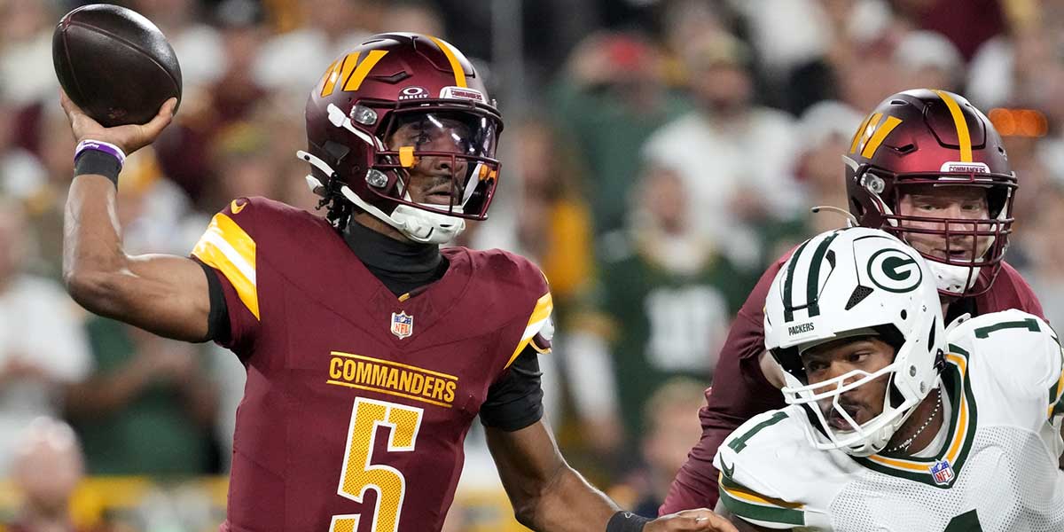 Washington Commanders quarterback Jayden Daniels (5) passes against Green Bay Packers defensive end Micah Parsons (1) in the first quarter at Lambeau Field.