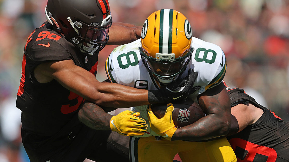 Green Bay Packers running back Josh Jacobs (8) is brought down by Cleveland Browns defensive end Joe Tryon-Shoyinka (90) and linebacker Carson Schwesinger (49
