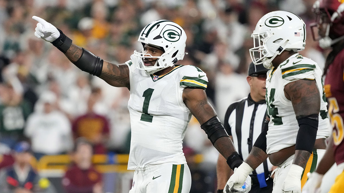 Packers defensive end Micah Parsons (1) reacts in the first quarter against the Washington Commanders at Lambeau Field with Cam Newton in the background