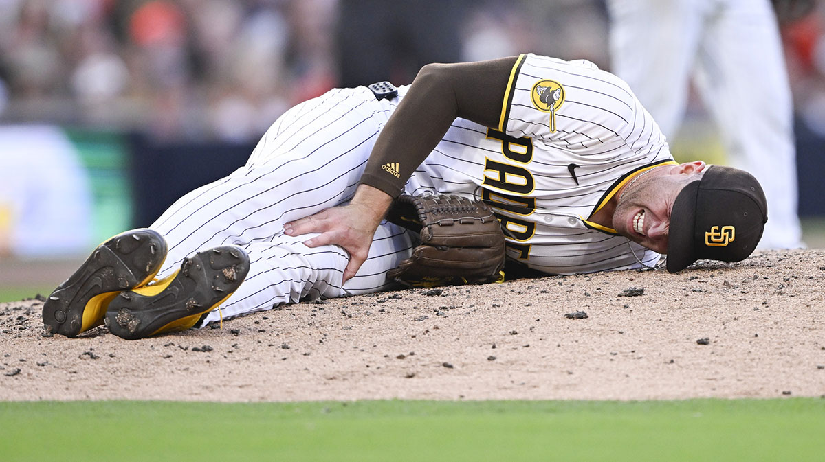 Padres relief pitcher Jason Adam (40) lies on the ground