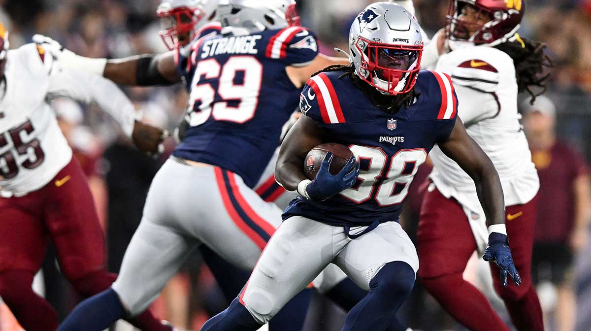 New England Patriots running back Rhamondre Stevenson (38) runs against the Washington Commanders during the first half at Gillette Stadium.
