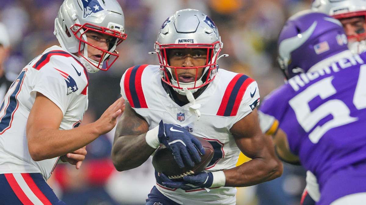 New England Patriots running back TreVeyon Henderson (32) runs with the ball against the Minnesota Vikings in the first quarter at U.S. Bank Stadium.
