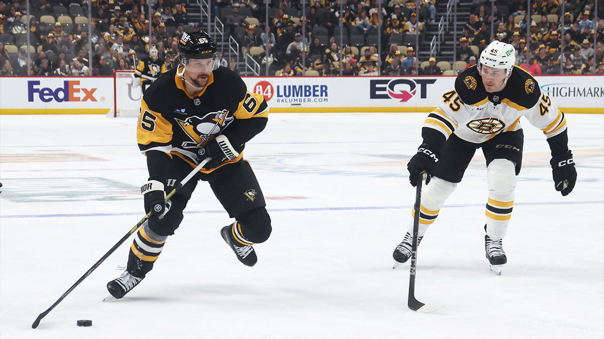 Pittsburgh Penguins defenseman Erik Karlsson (65) moves the puck against Boston Bruins left wing Cole Koepke (45) during the third period at PPG Paints Arena.